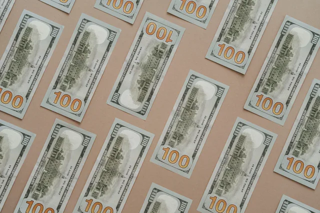 Patterned display of 100 US dollar bills, showcasing wealth and finance themes. Finansiel beredskab ved skalering af SMV'er