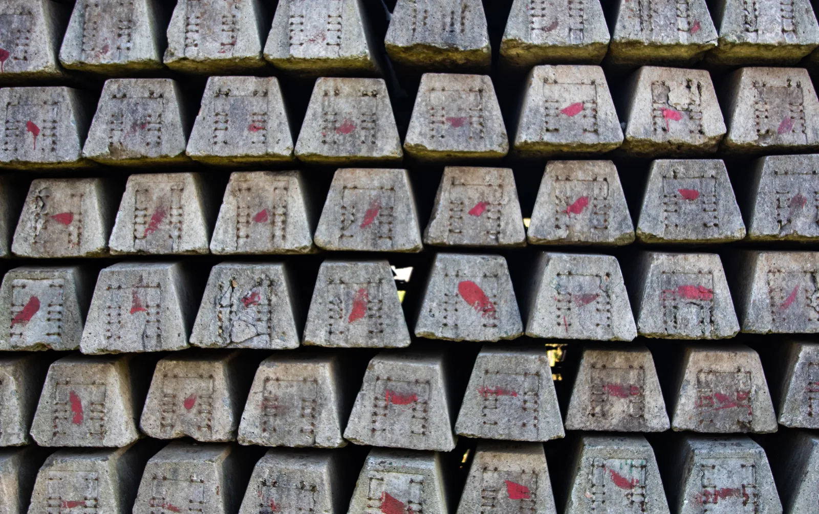 Close-up of stacked concrete blocks with red markings, showcasing industrial texture.
